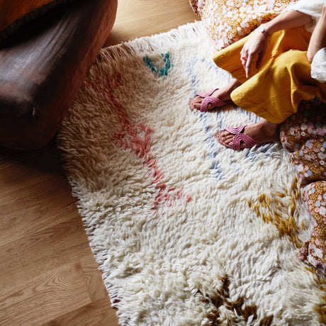 Juno Beni rug with multi-coloured large aztec inspired motifs on float style parchment woven rug. Finished with generous fringed edging.