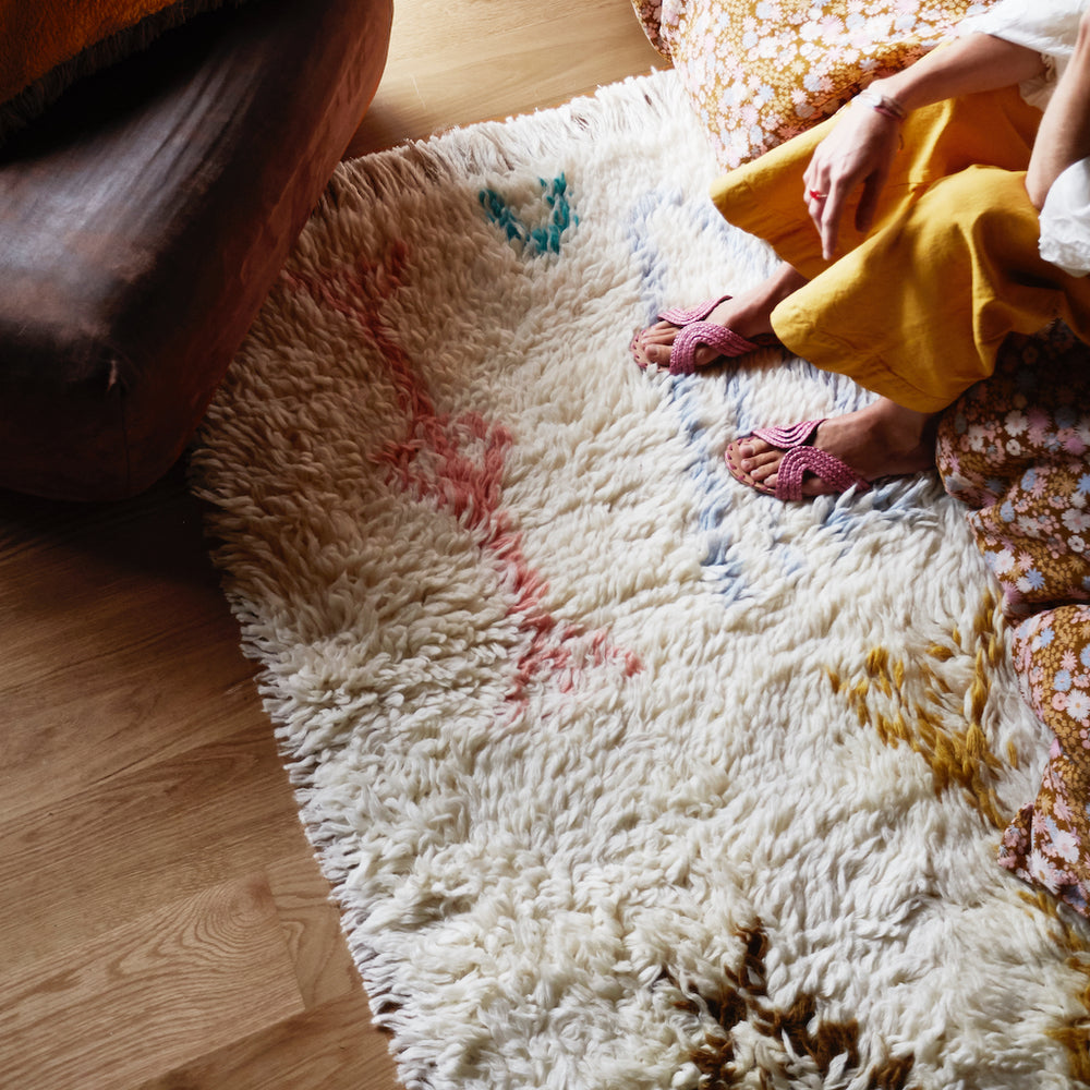 Juno Beni rug with multi-coloured large aztec inspired motifs on float style parchment woven rug. Finished with generous fringed edging. 